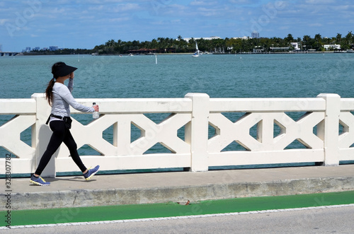 Young woman power walking across the Venetia  Causeway in Miami Beach,Forida