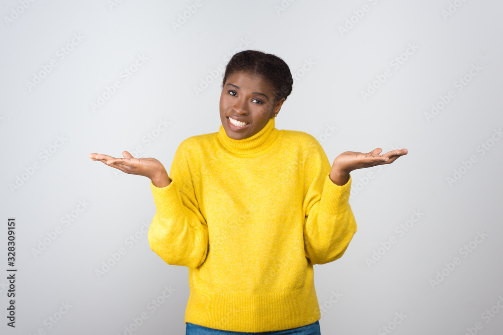 Uncertain young woman looking at camera. Portrait of doubtful young African American woman gesturing with hands and looking at camera isolated on white background. Doubt concept Uncertain young woman looking at camera. Portrait of doubtful young African American woman gesturing with hands and looking at camera isolated on white background. Doubt concept