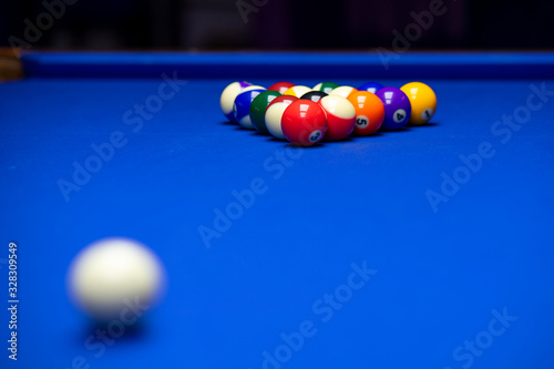 Colorful balls on a blue pool table. Set up and ready to play. Selective focus.