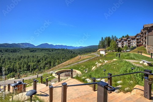 Beautiful open valley with Cascade mountains and pine trees and large lodge with deck. © Iriana Shiyan