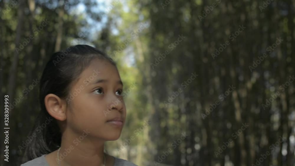 Asian cute girl walking on the footpath among mangrove forest under sunlight. Young female children watching beautiful scenery in the tropical rain forest. Slow motion. Asian cute girl walking on the footpath among mangrove forest under sunlight. Young female children watching beautiful scenery in the tropical rain forest. Slow motion.