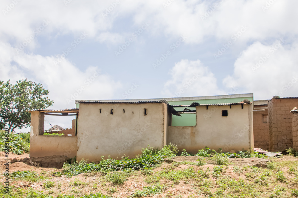 View of traditional village, zinc sheet on roof houses and terracotta brick walls, cloudy sky as background, in Angola View of traditional village, zinc sheet on roof houses and terracotta brick walls, cloudy sky as background, in Angola