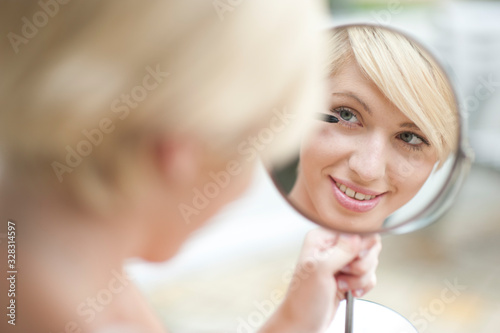 Beautiful young woman with a mirror