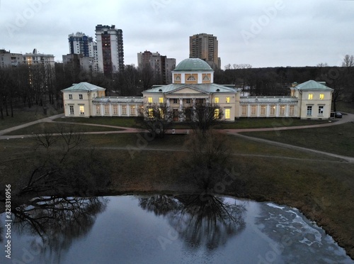 Aerial view from the top  of A pond in the park Alexandrino and Chernyshev cottage in St. Petersburg. Russia. Great estate manor with light in windows at sunset. Skysrabbers on backstage photo