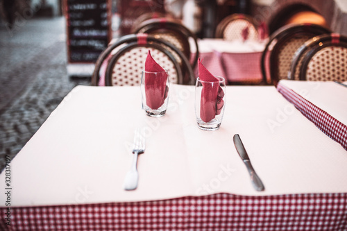 Table with a white tablecloth and appliances for two - outdoor cafe