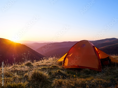 Tent in the mountains at sunset.