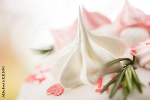 Fototapeta Naklejka Na Ścianę i Meble -  Close up view of delicious easter cake with pink and white meringue and rosemary