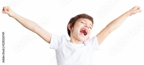 Cute child with short hair yawns sweetly, stretching her arms, kid wants to sleep, isolated white background, tiredness. Close up portrait. Sleeping time for children