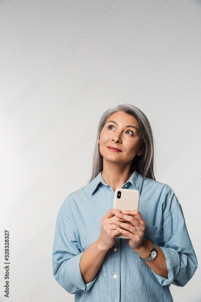 Image of adult mature woman with long white hair holding cellphone Image of adult mature woman with long white hair holding cellphone