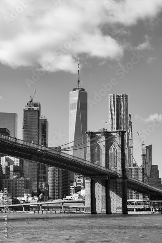 Black and White Photo of the Brooklyn Bridge with an American Flag over the East River with the Lower Manhattan New York City Skyline