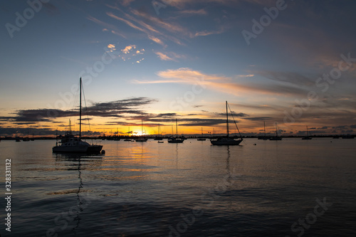sailboats anchored together silhouette with sunset in background © Daniel Wedeking