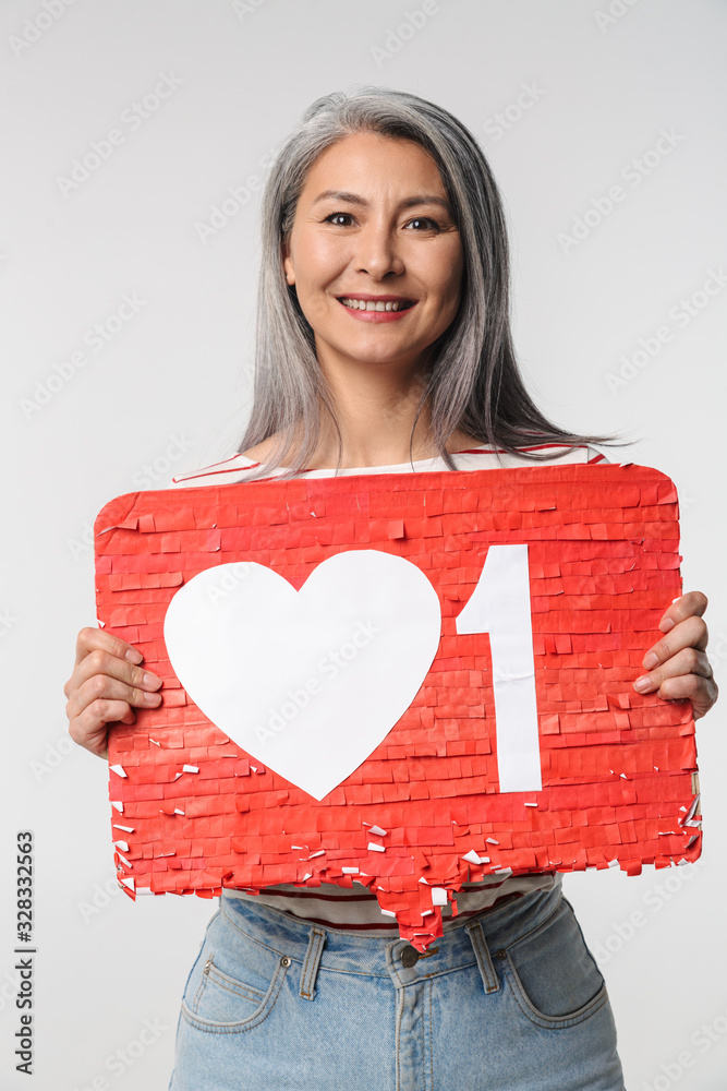 Image of adult mature happy woman holding heart like symbol on placard Image of adult mature happy woman holding heart like symbol on placard