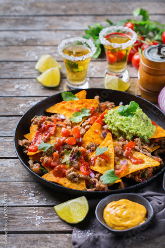 Chips nachos with beef, guacamole, chili, cheese salsa, tequila