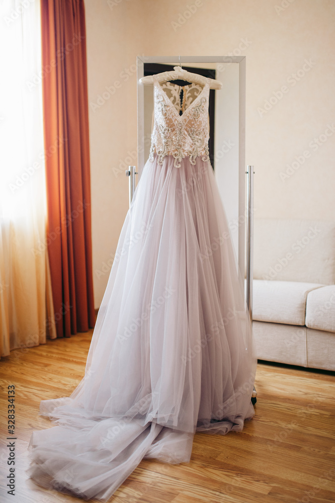 Purple wedding dress hanging on a mirror in the room Purple wedding dress hanging on a mirror in the room