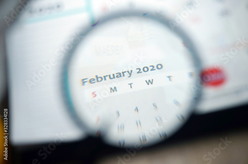 February 2020 Calender under magnifying glass. Selective focus. 