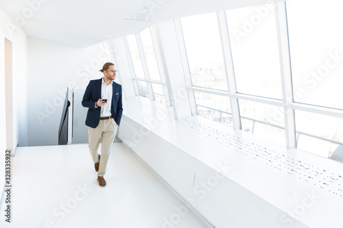 Serious young businessman indoors in office