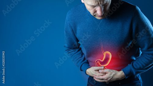 Man touching stomach painful suffering from stomachache causes, gastric ulcer or gastrointestinal system disease. Healthcare and health insurance concept. photo