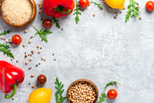 Healthy food. Vegetables, lemon and chickpeas on a concrete background, top view, free space for text. Vegetarian and vegan food concept, copy space. Raw food for cooking Mediterranean cuisine.