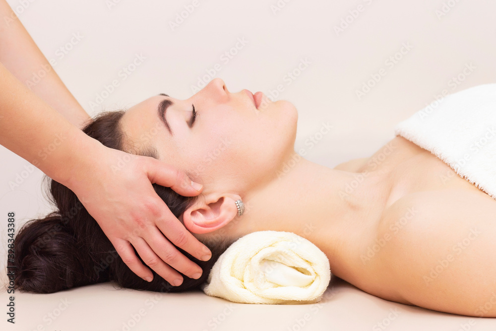head and temporal massage in a spa salon for a girl. concept of health massage. light background. head and temporal massage in a spa salon for a girl. concept of health massage. light background.