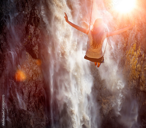 Eine Frau schaukelt vor einem Wasserfall
