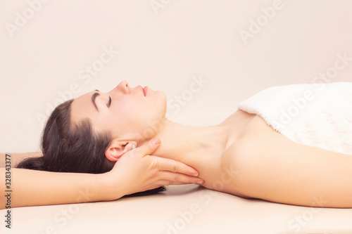 neck massage in a spa salon for a girl. concept of health massage. light background.