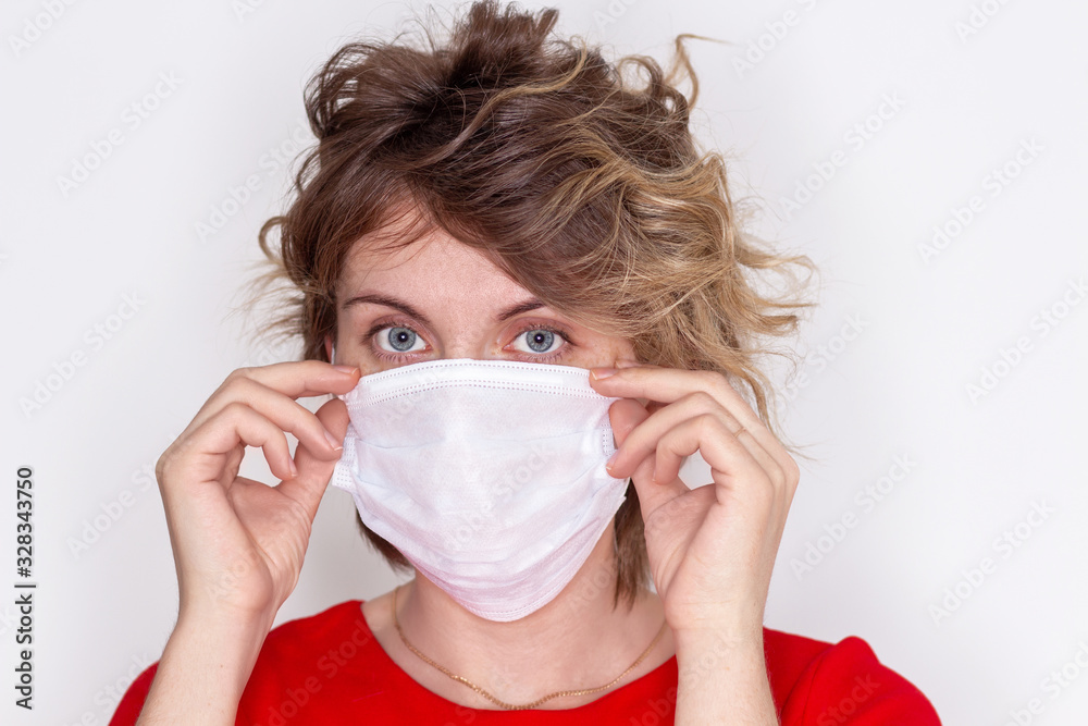 Cute girl wearing a health mask, looking straight, isolated on a white background, flu Epidemic, dust Allergy, virus protection. Concept of air pollution in the city, close-up Cute girl wearing a health mask, looking straight, isolated on a white background, flu Epidemic, dust Allergy, virus protection. Concept of air pollution in the city, close-up