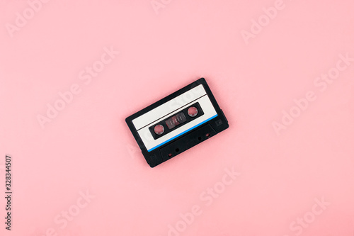 Retro audio cassette tape flat lay on colorful pink background top view with copy space. Creative fashion design in minimal retro 80-s style. Music, radio, dj concept. Web banner template. Stock photo