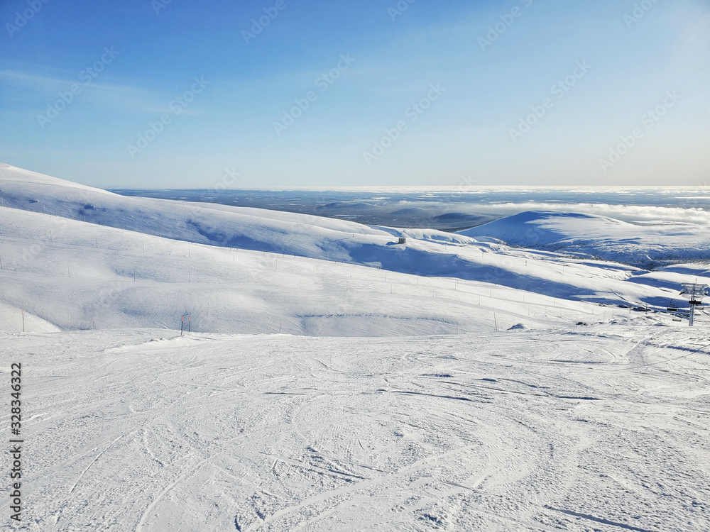 Ski slope with piste, early sunny morning, resort in Finland. Sport lifestyle, health Ski slope with piste, early sunny morning, resort in Finland. Sport lifestyle, health