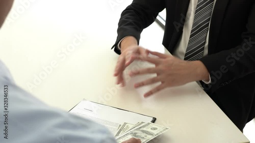 4k video of businessman manager refusing receive money in the envelope disgusted male employee giving to take bribe, corruption concept. photo