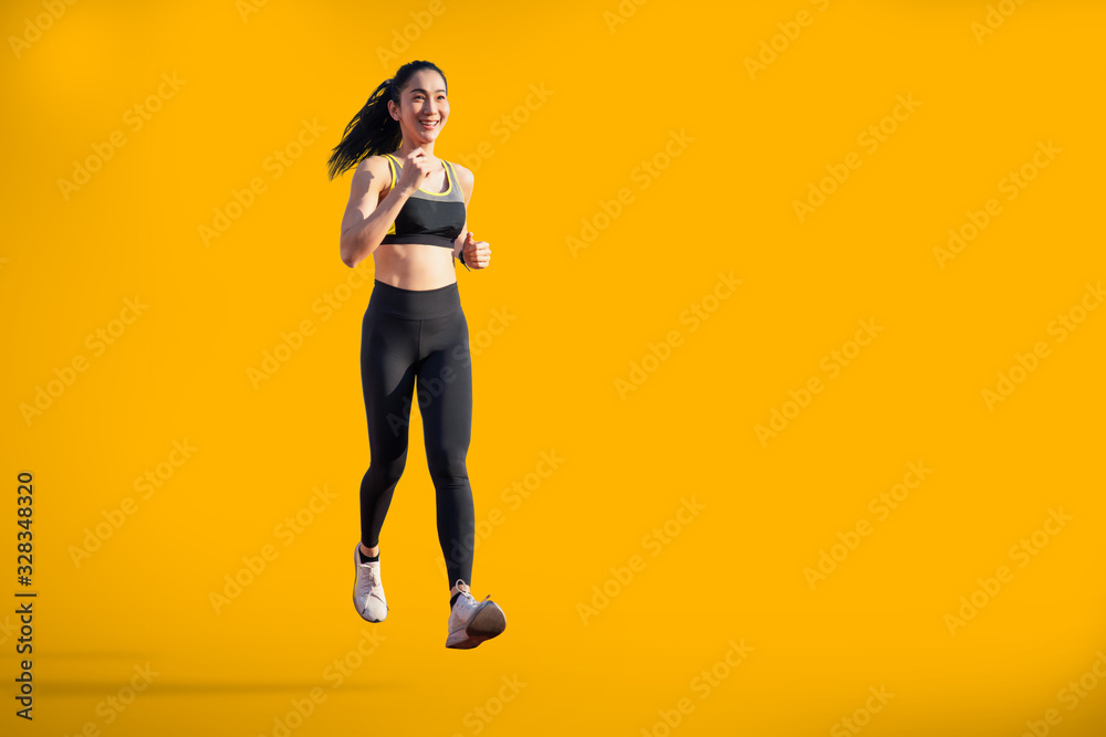 asian woman running on yellow background with copy space