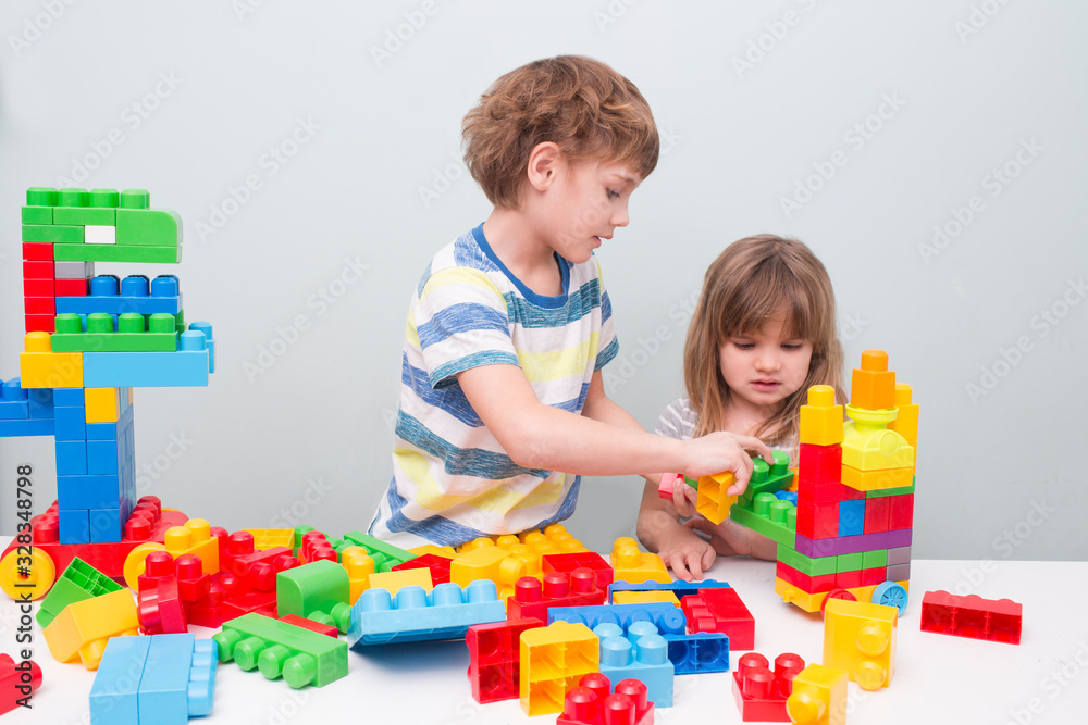 Little kids playing with lots of colorful plastic blocks constructor and builds the robot indoor. Little kids playing with lots of colorful plastic blocks constructor and builds the robot indoor.
