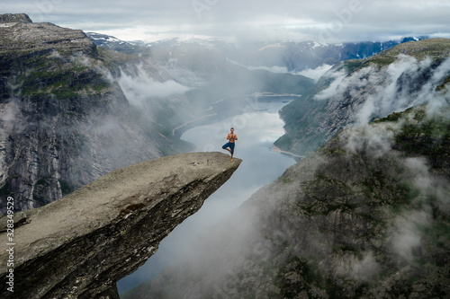 Fototapet Yog is praying on the edge Trolltunga. Norway
