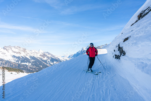 A middle aged male enjoys skiing on the slopes on Mannlichen mountain in Grindelwald, Switzerland. Active lifestyle concept.