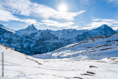 Winter landscape with snow covered peaks seen from the First mountain in Swiss Alps in Grindelwald ski resort, Switzerland