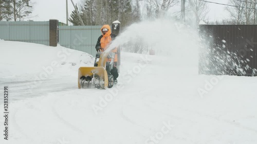 Man cleans snow with a snow thrower photo