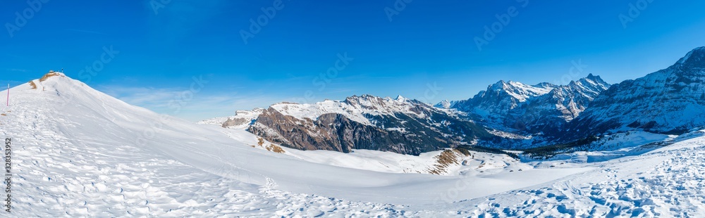 Wide parnoramic view of snow covered Swiss Alps from Mannlichen mountain in Grindelwald ski resort, Switzerland