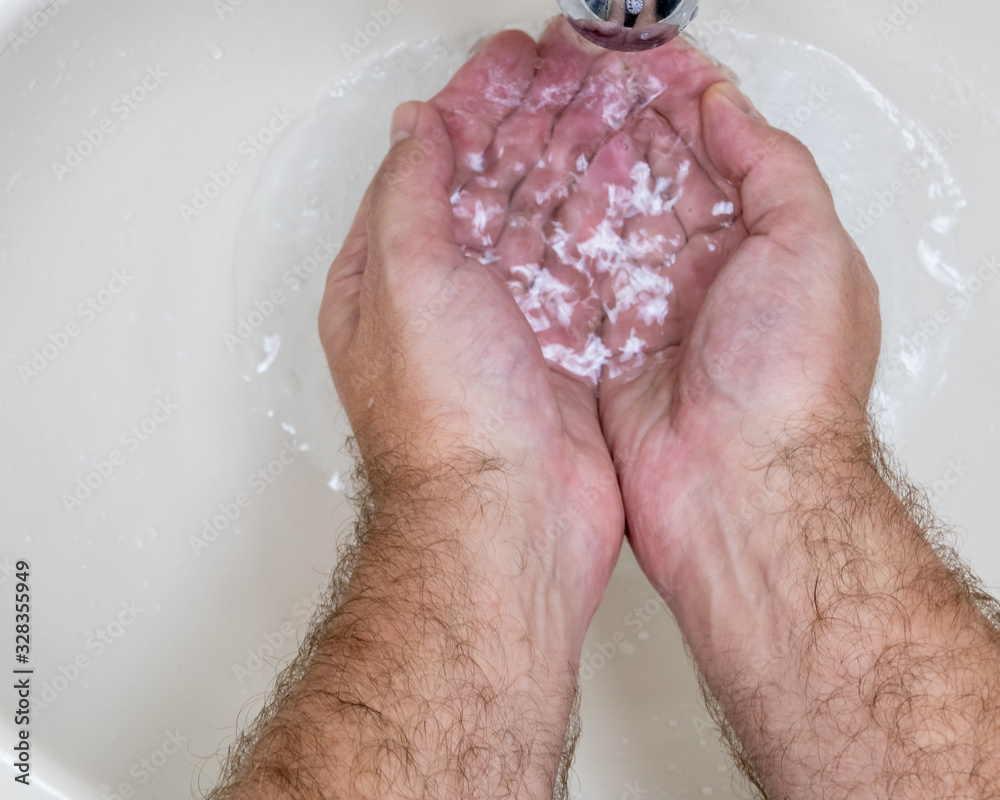 Fototapeta premium Man washing hands close-up from above