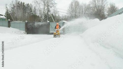 Man cleans snow with a snow thrower photo