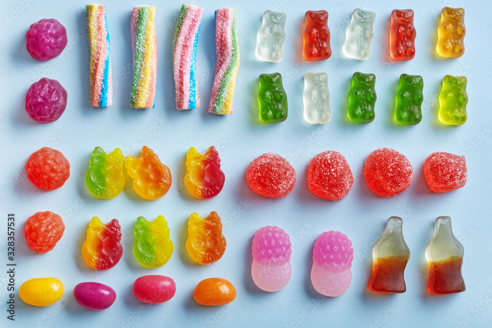 Candy variety flat lay on a blue background viewed from above. Top view ...