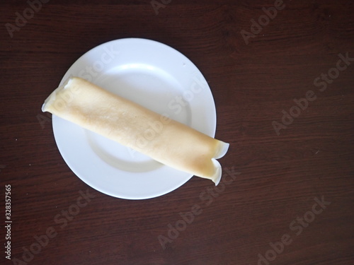   single rolled pancake on a white plate