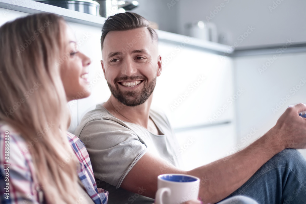 loving couple talking, sitting in the kitchen on the floor loving couple talking, sitting in the kitchen on the floor