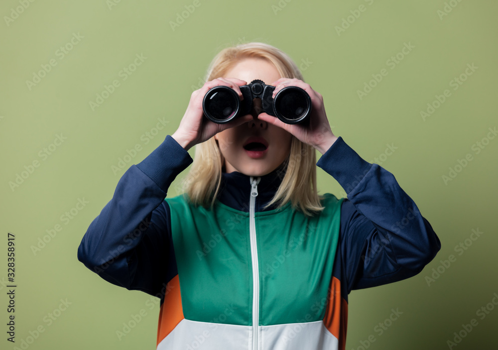 Beautiful blonde woman in 90s sport suit with binoculars Beautiful blonde woman in 90s sport suit with binoculars