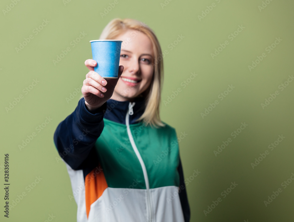 Beautiful blonde woman in 90s sport suit with paper cup Beautiful blonde woman in 90s sport suit with paper cup