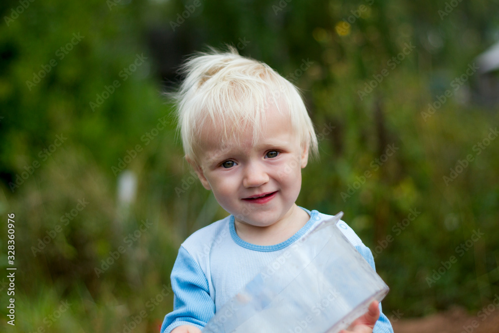 Portrait of cute funny blond baby outdoors on a summer day Portrait of cute funny blond baby outdoors on a summer day