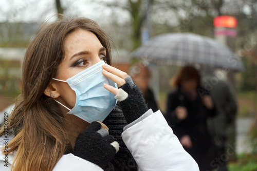 Woman outdoors in city with a face mask against infection and viruses such as flu, corona virus, sars or swine influenca