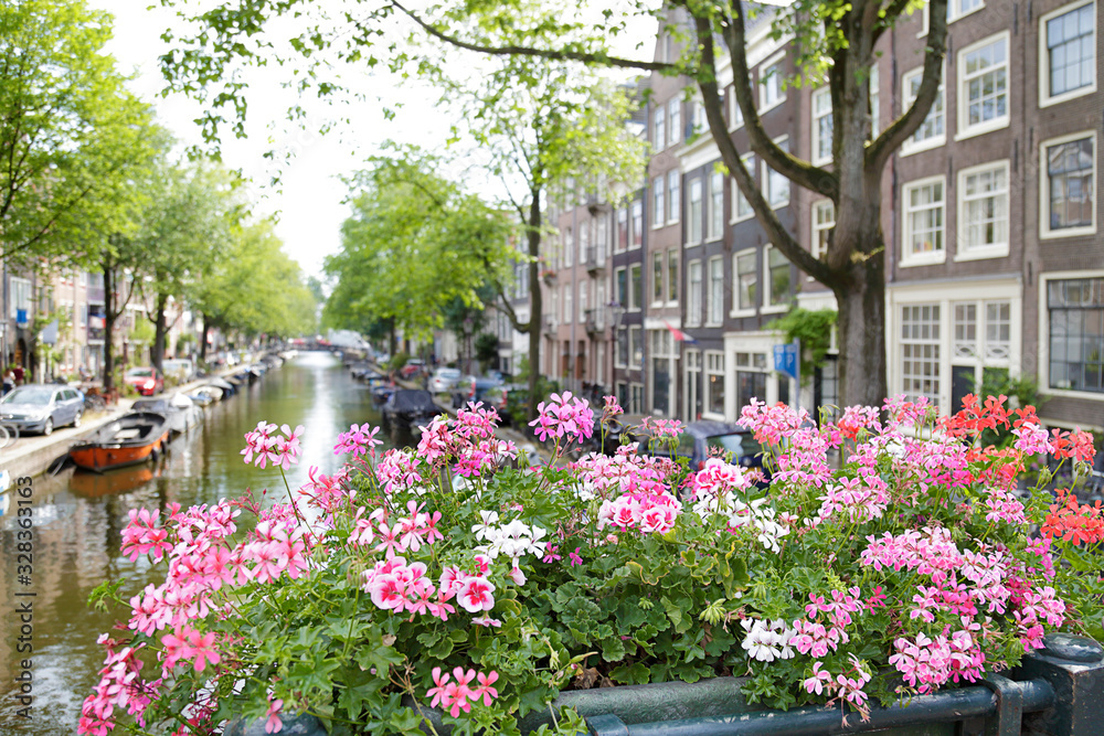 View of beautiful buildings and canal from a bridge with flowers, Amsterdam,  the Netherlands