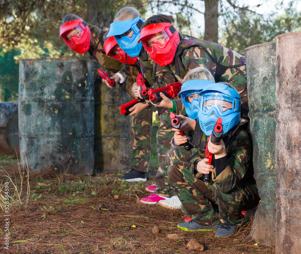 Kids paintball players aiming outdoors