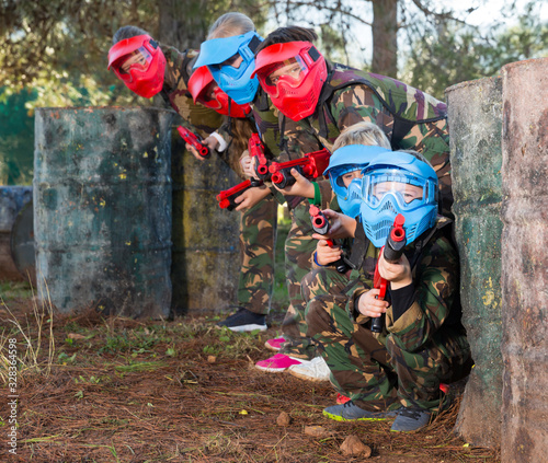 Kids paintball players aiming outdoors