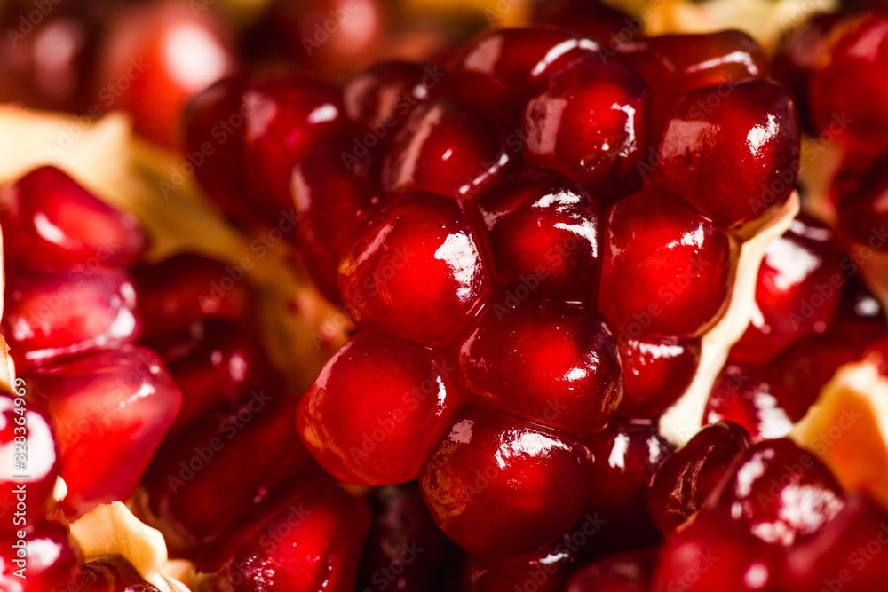 Broken red ripe pomegranate fruit on the dark rustic background. Selective focus. Shallow depth of field. Broken red ripe pomegranate fruit on the dark rustic background. Selective focus. Shallow depth of field.