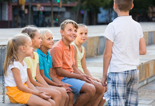 Smiling kids playing charades outdoors